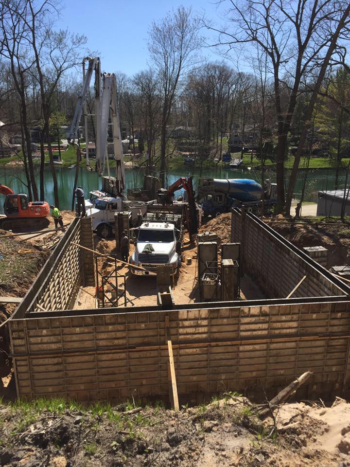 Crews pouring concrete walls for house with river view